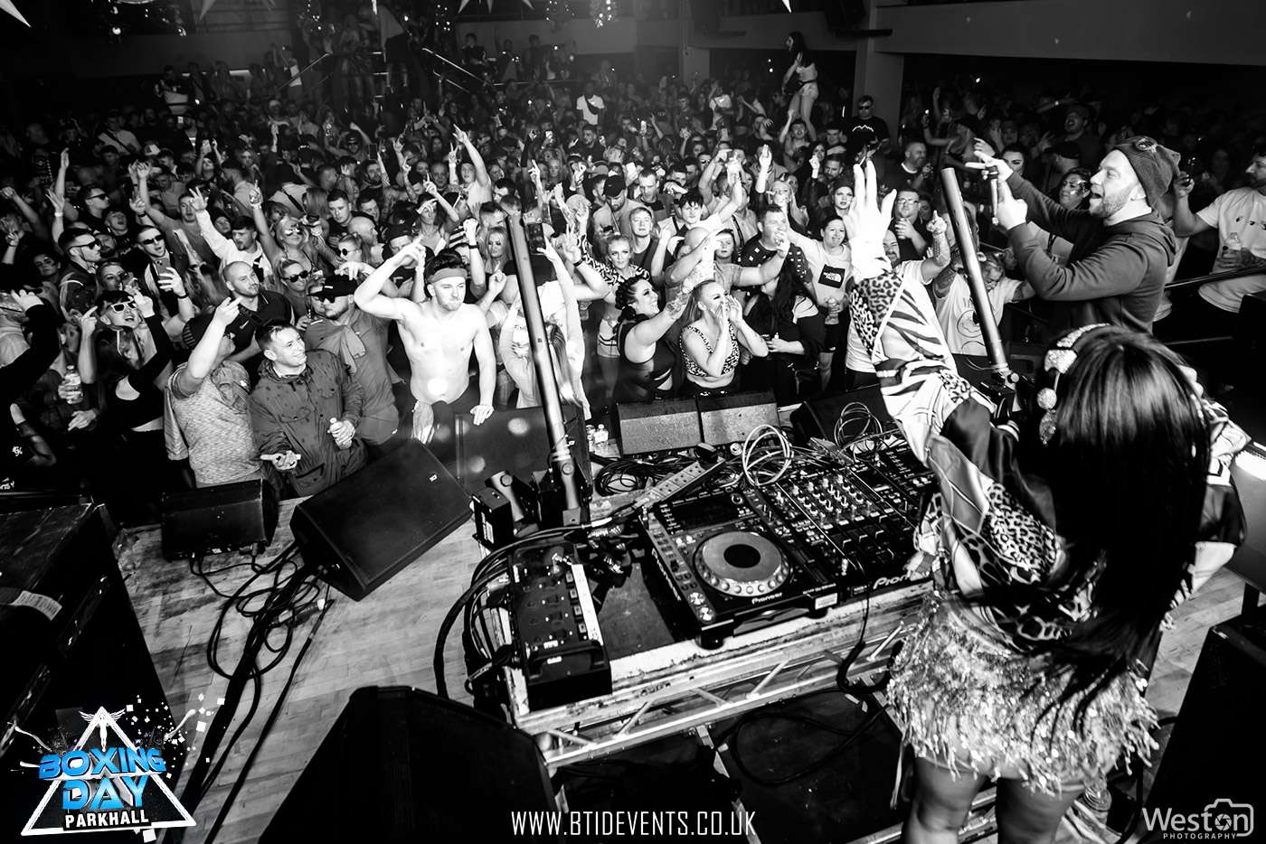 A view from behind the DJ decks over a packed dancefloor, from Hannah Taylor’s official site